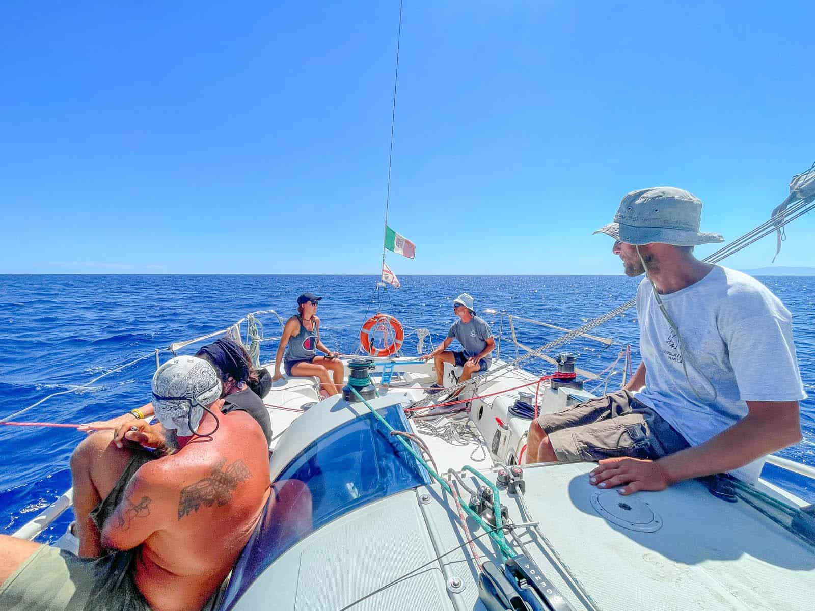 Gruppo di giovani partecipanti su una barca a vela durante un corso intensivo estivo in Sardegna.