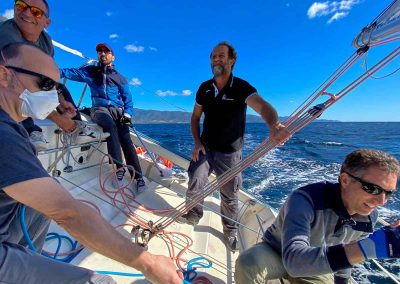 Principianti entusiasti imparano a veleggiare durante lezioni di vela in Sardegna